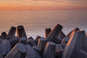 Concrete Sea Defences on Llanddulas Beach backed by the distant Gwynt y Mor Offshore Wind Farm at sunset, Llanddulas, near Abergele, Conwy County Borough, North Wales, UK