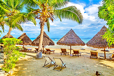 Beach umbrellas and deck chairs by the sea at Nosy Be island, Nosy Komba, North West Madagascar, Indian Ocean, Africa