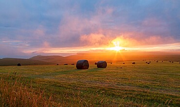 Hay bales at Sunset in the South Downs National Park near Beachy Head, Eastbourne, East Sussex, England.