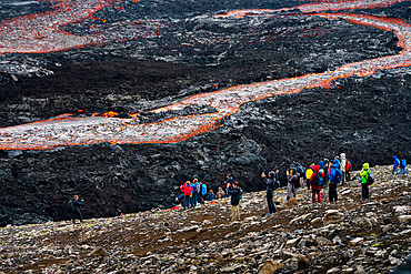 Tourists watching flowing lava at Fagradalsfjall volcano, Reykjanes Peninsula, Iceland