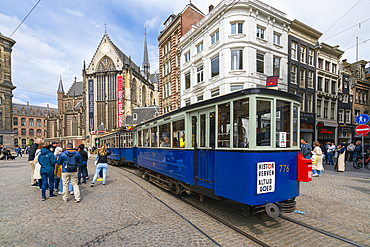 Blue tram and The New Church (De Nieuwe Kerk) in background at Dam Square, Amsterdam, The Netherlands, Europe