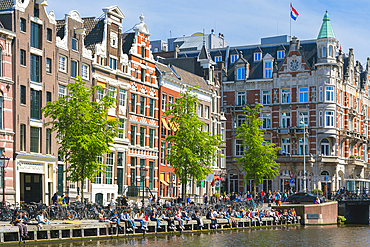 Students sitting by Rokin canal, Amsterdam, The Netherlands, Europe