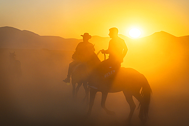 Two cowboys on horses at sunset, Hacilar, Kayseri, Cappadocia, Anatolia, Turkey, Asia Minor, Asia