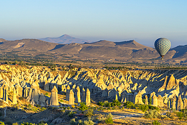 Aerial view of hot air balloon over rock formations in Love Valley at sunrise, Goreme, Goreme Historical National Park, UNESCO Worrld Heritage Site, Cappadocia, Central Anatolia Region, Anatolia, Turkey, Asia Minor, Asia