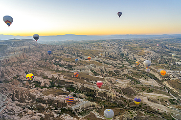 Aerial view of Cavusin and hot air balloons at dawn, Avanos District, Nevsehir Province, Cappadocia, Central Anatolia Region, Anatolia, Turkey, Asia Minor, Asia