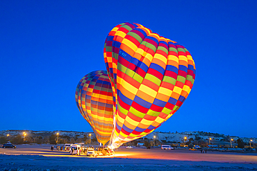 Two colorful hot air balloons at launch at twilight, Goreme, Cappadocia, Anatolia, Turkey, Asia Minor, Asia