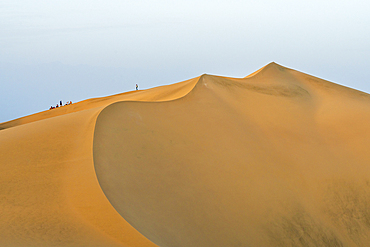 Distant view of tourists watching sunset from sand dune in desert, Huacachina, Ica District, Ica Province, Ica Region, Peru