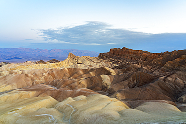 Natural rock formations with Manly Beacon at Zabriskie Point at dusk, Death Valley National Park, Eastern California, California, USA