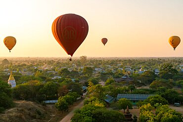 Hot-air balloons at sunrise over village near Bagan, Myanmar