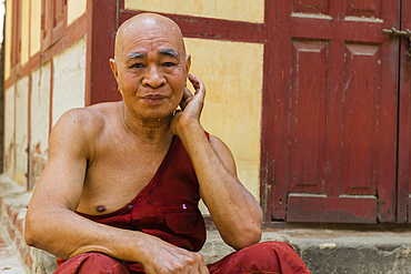 Senior monk resting outside of Shwenandaw Temple, Mandalay, Myanmar (Burma), Asia