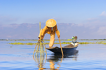 Fisherman with traditional conical net on boat, Lake Inle, Shan State, Myanmar (Burma), Asia