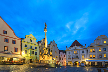 Fountain and Plague Column with traditional houses with gables in background at twilight, Namesti Svornosti Square in historical center, UNESCO World Heritage Site, Cesky Krumlov, Czech Republic (Czechia), Europe