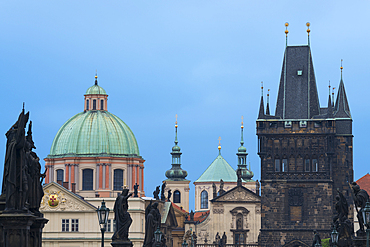 Details of statues and spires at Charles Bridge, featuring dome of Church of Saint Francis of Assisi and Old Town Bridge Tower, UNESCO World Heritage Site, Prague, Bohemia, Czech Republic (Czechia), Europe