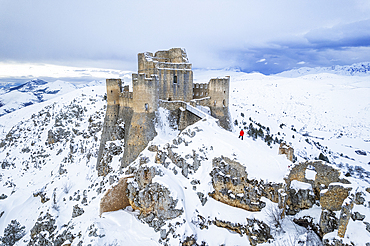 Man admiring the snowy medieval castle of Rocca Calascio after heavy snowfall, Rocca Calascio, Gran Sasso and Monti della Laga National Park, L'Aquila province, Abruzzo region, Apennines, Italy, Europe