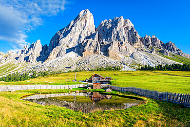 Sass de Putia and the reflection of a mountain hut in a small pond, Passo delle Erbe, Dolomites, South Tyrol, Italy, Europe