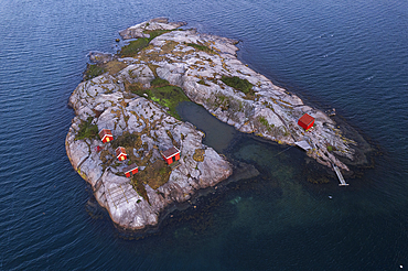 Red traditional boat houses and cottages on a rocky island surrounded by the ocean, Bohuslan, West Sweden, Scandinavia, Europe