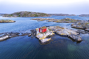 Scenic lonely wooden red house on a rocky island at dusk, Bohuslan, Sweden, Scandinavia, Europe