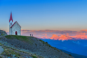 Man enjoys sunset over Dolomites at the pilgrimage church of Lazfons, Chiusa, Bolzano district, South Tyrol, Italy, Europe