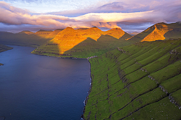 Aerial shot of the dramatic view of Funningur with pink sky at dawn, Eysturoy island, Faroe islands, Denmark, Europe