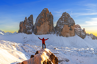 Happy hiker enjoys the view of the Tre Cime di Lavaredo at sunset, winter view, Tre Cime di Lavaredo (Lavaredo peaks) (Drei Zinnen), Sesto (Sexten), Dolomites, South Tyrol, Italy, Europe