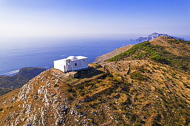 Aerial view of the white Chapel of San Costanzo on top of a mountain surrounding the sea of Amalfi coast, Punta Campanella, Massa Lubrense municipality, Naples province, Campania region, Italy, Europe