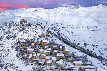 Aerial winter view of the snow covered medieval village of Rocca Calascio with the castle and pink sky at sunset, Rocca Calascio, Gran Sasso e Monti della Laga National Park, Campo Imperatore, L'Aquila province, Abruzzo region, Italy, Europe