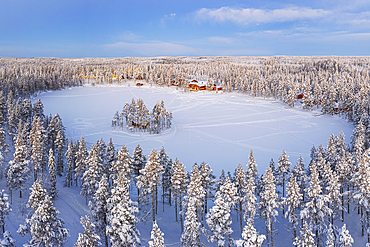 Aerial view of a tourist winter resort in the snow covered forest and the frozen lake in Kangos, Pajala, Norrbotten, Norrland, Lapland, Sweden, Scandinavia, Europe