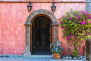 Loreto, Baja California Sur, Mexico. November 17, 2021. Arched doorway in a pink stucco wall.