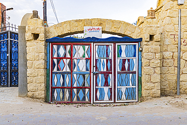 Faiyum, Egypt. February 19, 2022. Painted gate in a wall in the village of Faiyum.