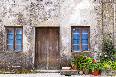 Europe, Portugal, Monsanto. Wooden door and windows in an old stucco house.