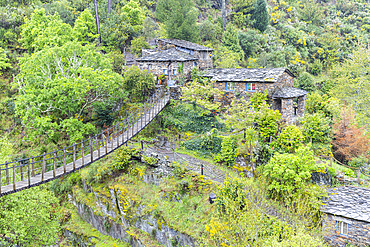 Europe, Portugal, Piadao. April 22, 2022. Suspension bridge leading to a stone house.