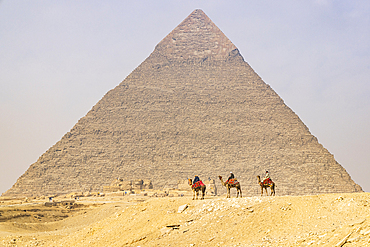 Giza, Cairo, Egypt. February 18, 2022. Men on camels at the Great Pyramid complex in Giza.