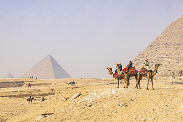 Giza, Cairo, Egypt. February 18, 2022. Men on camels at the Great Pyramid complex in Giza.