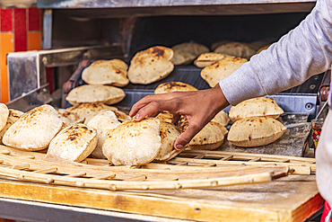 Manshiyat Naser, Garbage City, Cairo, Egypt. Baker making fresh pita bread, known as aish, in Manshiyat Naser, Garbage City, Cairo.