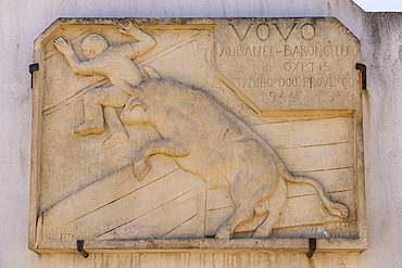 Saintes-Maries-de-la-Mer, Bouches-du-Rhone, Provence-Alpes-Cote d'Azur, France. July 3, 2022. Historic wall plaque of a bull chasing a man in Saintes-Maries-de-la-Mer.