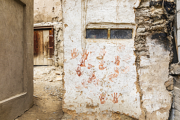 Margib, Sughd Province, Tajikistan. Red hand prints on a traditional stucco building.