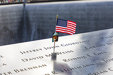 Manhattan, New York City, New York, USA. November 3, 2021. Small flag and photograph at the 9/11 Memorial in Lower Manhattan.