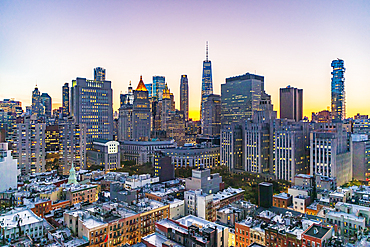 Manhattan, New York City, New York, USA. Lights in the windows of skyscrapers at sunset.