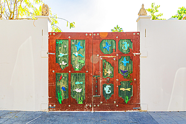 Todos Santos, Baja California Sur, Mexico. November 11, 2021. Wooden gate decorated with birds and aquatic creatures.