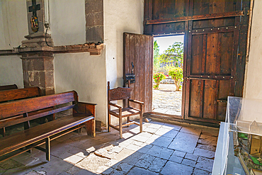 San Ignacio, Mulege, Baja California Sur, Mexico. November 14, 2021. Chair holding open the door to the chapel in the San Ignacio Mission.