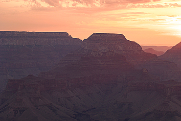 Golden light envelops the Grand Canyon during a summer sunrise, Tusayan, Arizona, United States of America, North America