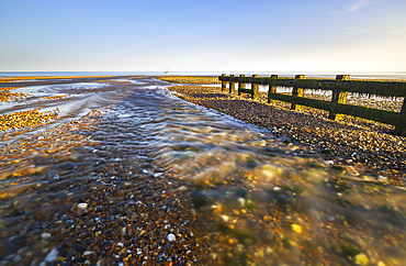 A boat off Cuckmere Haven beach at sunset, East Sussex, England, United Kingdom, Europe