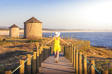 A tourist observes sunset at Windmills of Apulia during summer, Apulia, Esposende, Braga, Norte, Portugal, Iberian Peninsula, Western Europe