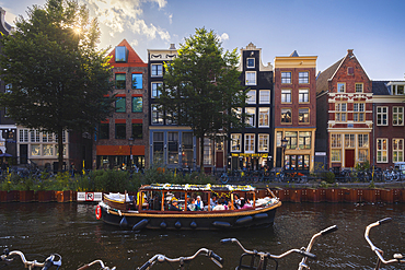 Canals and houses of Amsterdam with a boat during sunset, Netherlands, North Holland, Western Europe