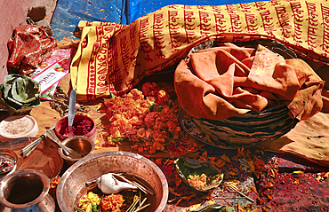 A religious offering of colorful petals, paints, powders, and more near a shrine in Bhaktapur, Nepal, Asia