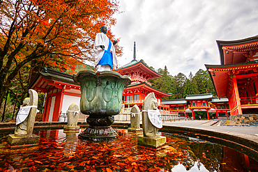 A serene fountain within the historic Enryaku-ji Temple complex on Mount Hiei, surrounded by vibrant autumn foliage. This UNESCO World Heritage site is a center of Tendai Buddhism and offers a tranquil escape near Kyoto, Japan.