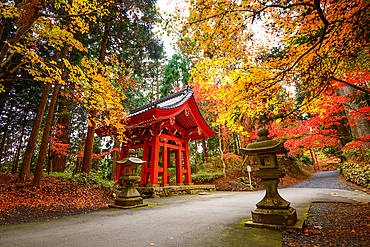 Traditional Shōrō bell tower surrounded by vivid autumn foliage on Mount Hiei, near the historic Enryaku-ji Temple, Japan.