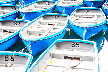 A detailed view of blue rowboats docked on the Arashiyama River in Kyoto, showcasing their arrangement and vibrant color.