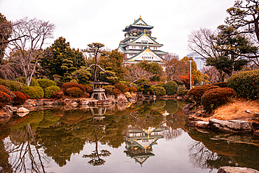 Osaka Castle in Japan Reflecting in a Pond of a japanese Castle. Autumnal Colors in Winter