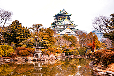 Osaka Castle in Japan Reflecting in a Pond of a japanese Castle. Autumnal Colors in Winter